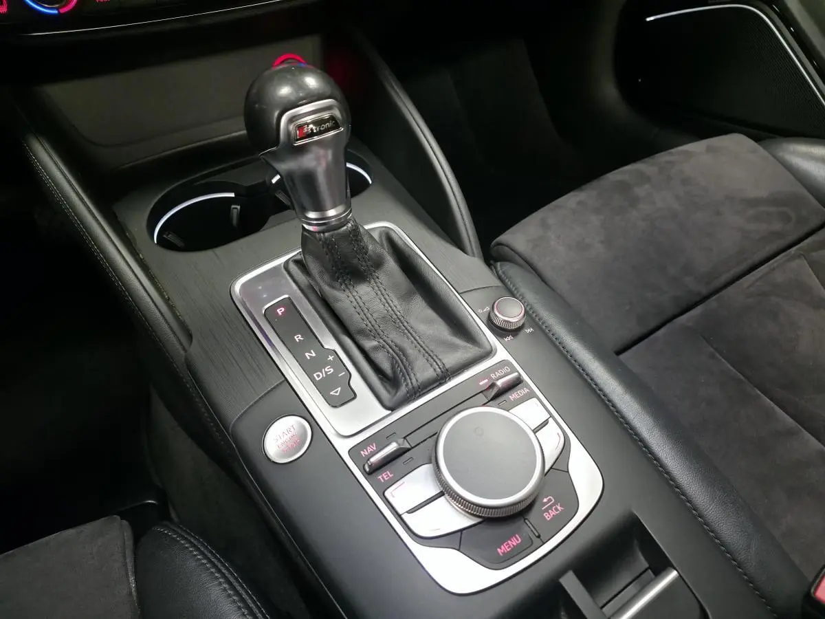 Vue rapprochée de la console centrale noire avec levier de vitesses automatique et siège en Alcantara gris foncé de l'Audi A3 Cabriolet.
