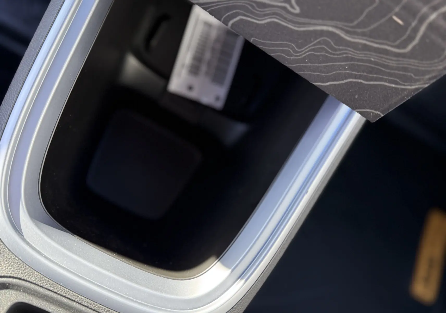 Gros plan sur la console centrale intérieure du Jeep Avenger Storm Grey, avec bouton Drive Mode et sellerie noire et orange.