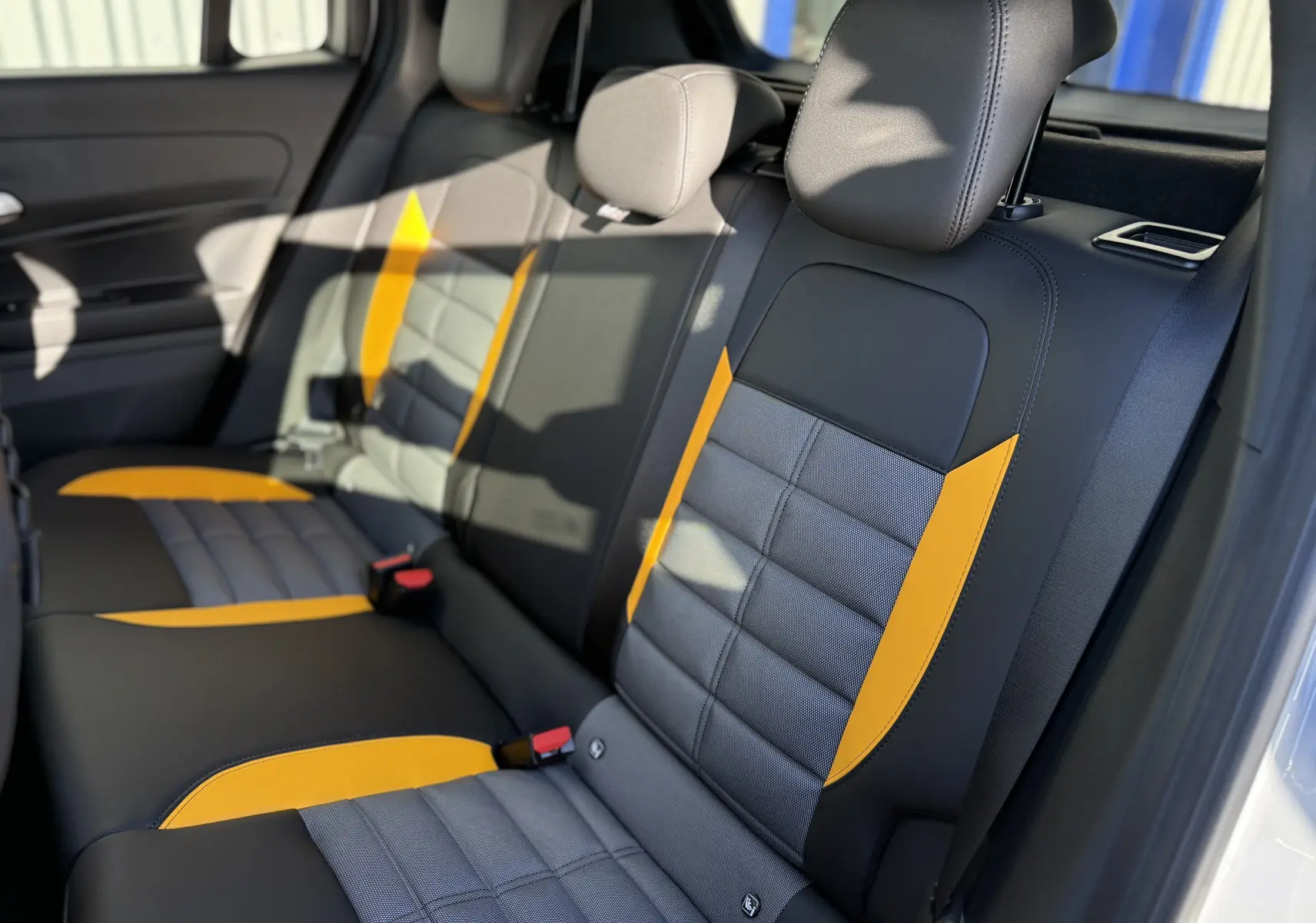 Vue intérieure côté droit des sièges arrière du Jeep Avenger 2025, avec sellerie noire et inserts jaunes contrastants.