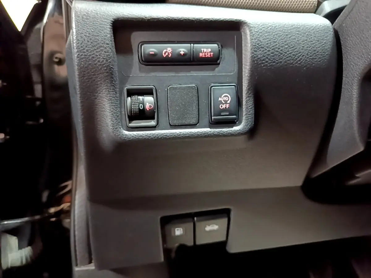 Détail du tableau de bord côté gauche de la Nissan Micra IG-T 90 N-Connecta noire avec commandes d'éclairage et ouverture.
