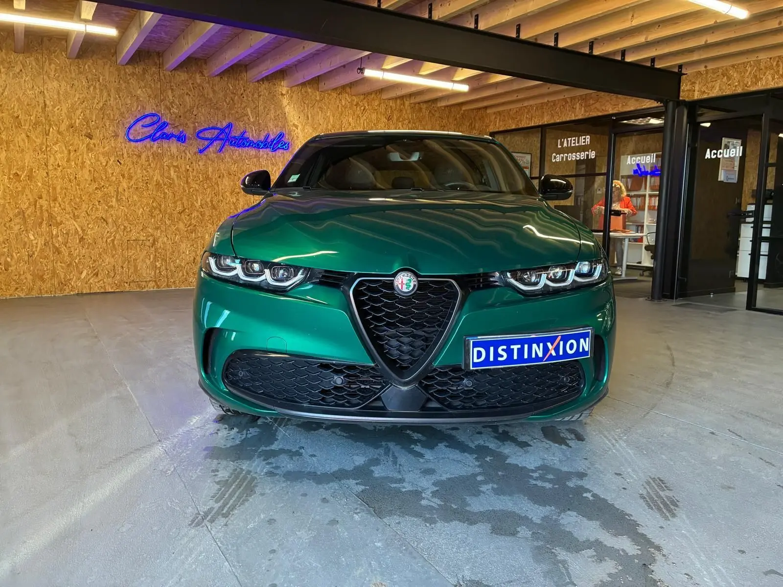 Vue frontale d'une Alfa Romeo Tonale 1.5 MHEV vert foncé, avec calandre emblématique en V et phares LED triples.