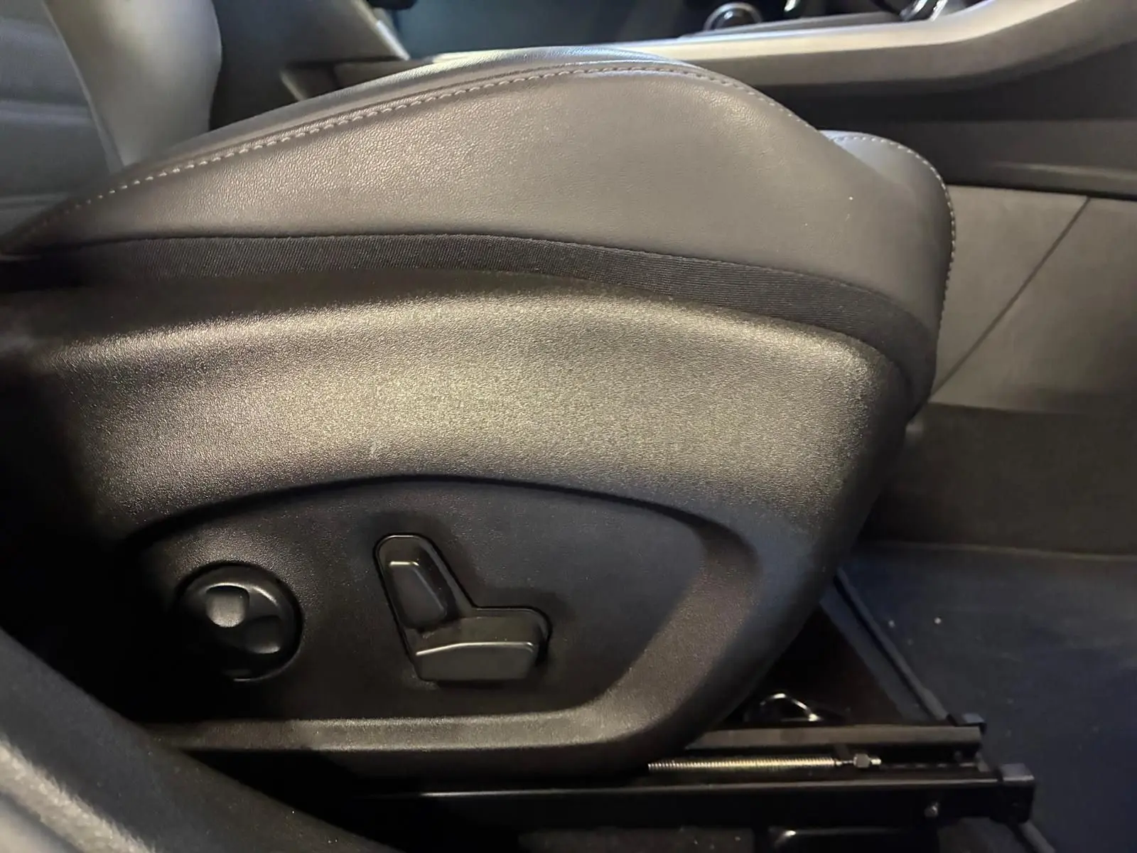 Gros plan sur les commandes de réglage électrique du siège avant en cuir noir de l'Alfa Romeo Tonale 2022.