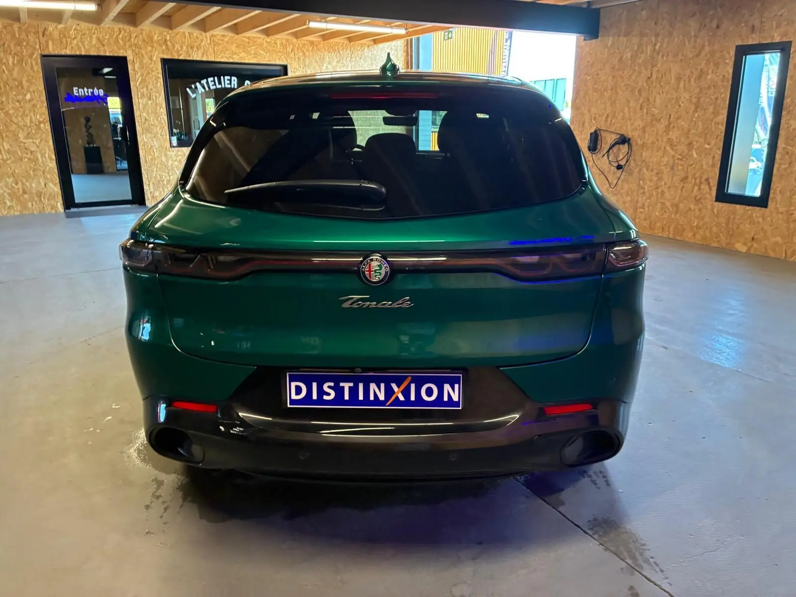 Vue arrière d'une Alfa Romeo Tonale vert foncé, avec feux arrière fins et logo centré sur le hayon.