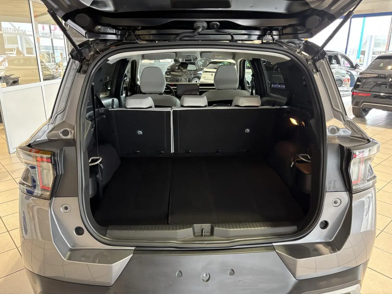Coffre ouvert vu de l'arrière d'un Citroën C3 Aircross gris avec banquette arrière relevée et intérieur noir.