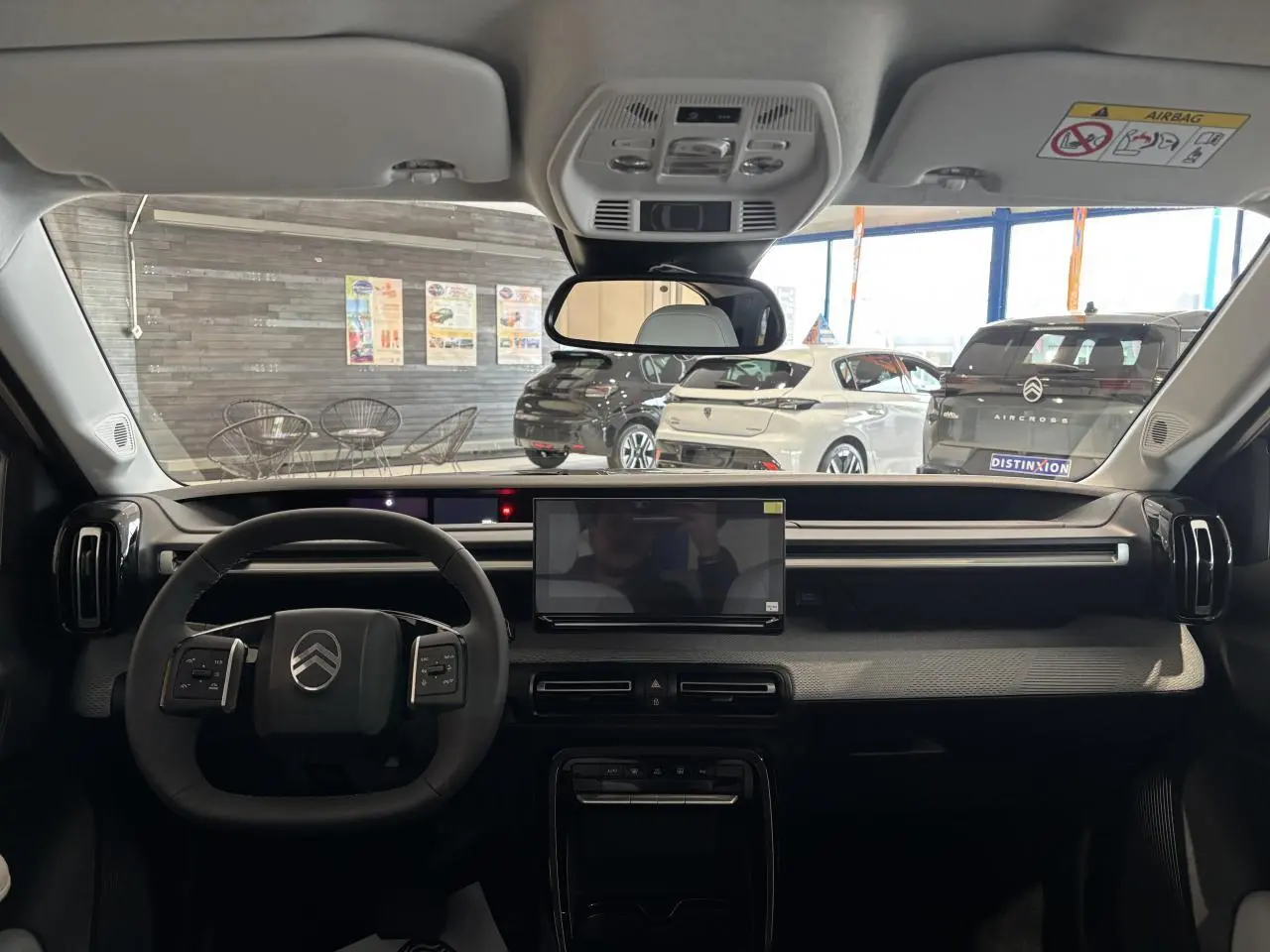 Vue intérieure avant du Citroën C3 Aircross 2026 gris et noir, avec écran tactile central et volant multifonctions.