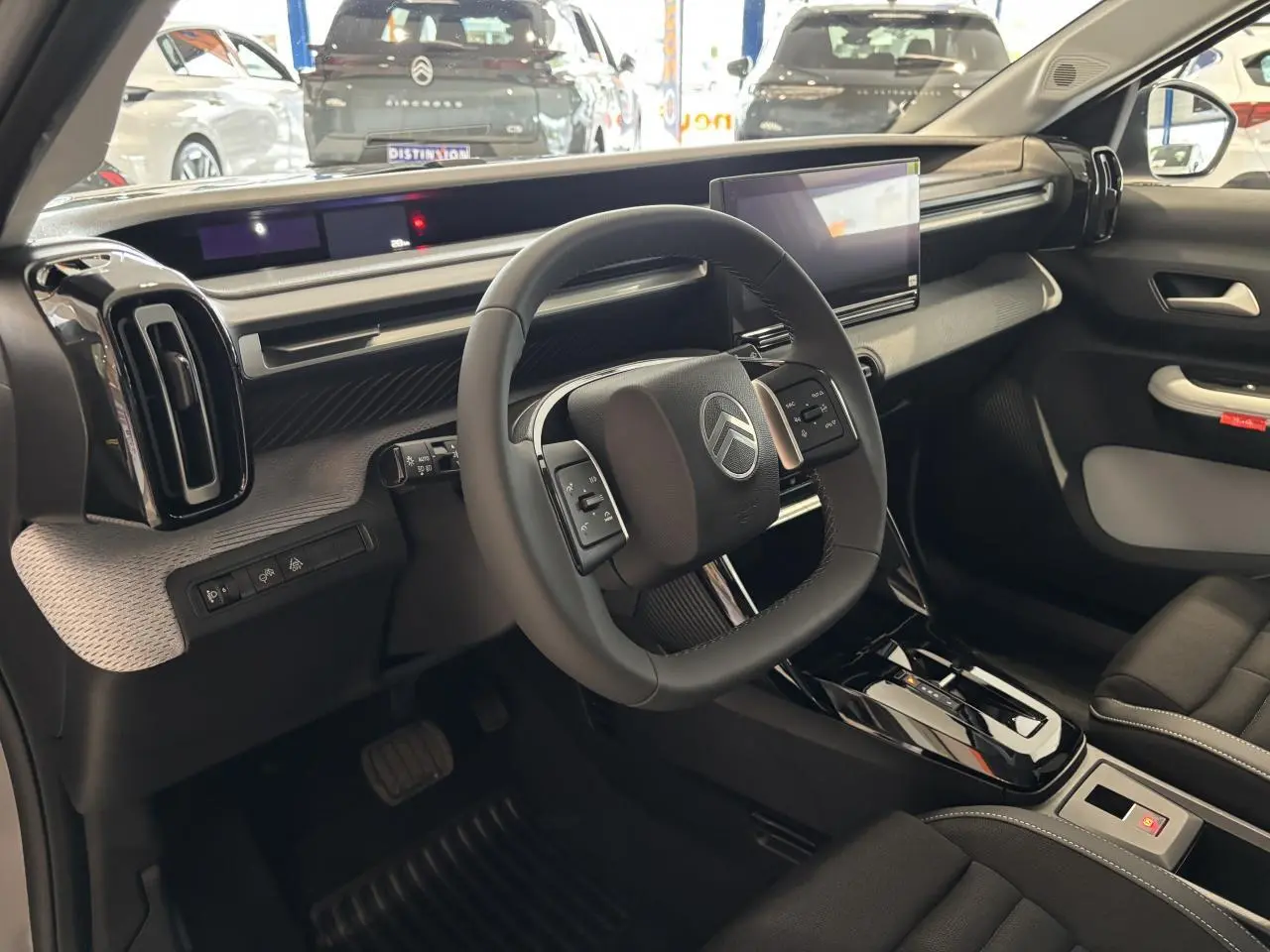 Intérieur avant droit du Citroën C3 Aircross 2026, volant carré, tableau de bord moderne avec écran tactile.