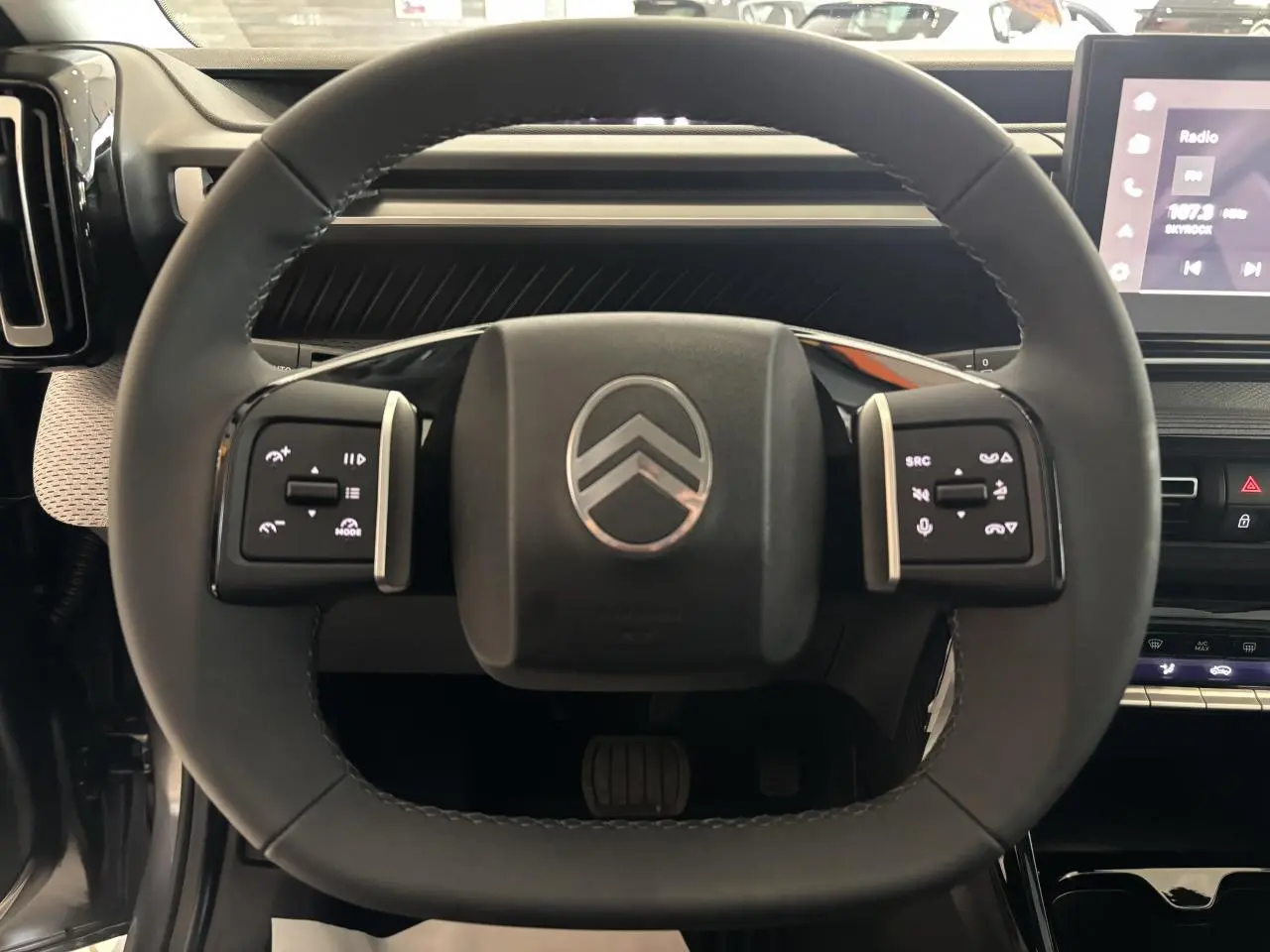 Vue rapprochée du volant multifonctions noir de la Citroën C3 Aircross 2026 avec logo chromé au centre.