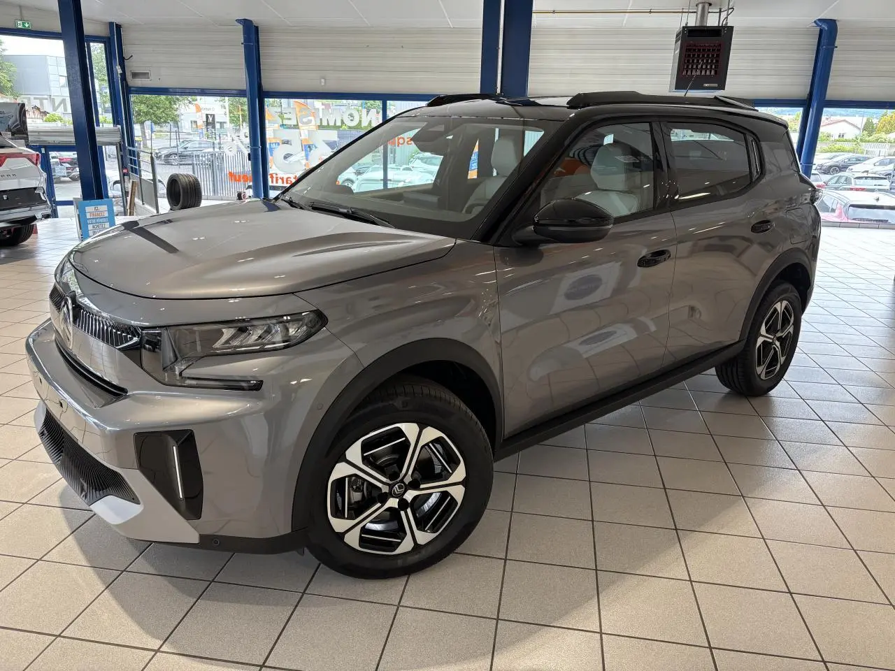 Vue 3/4 avant droite du Citroën C3 Aircross 2026 gris métallisé avec toit noir et jantes alliage diamantées.