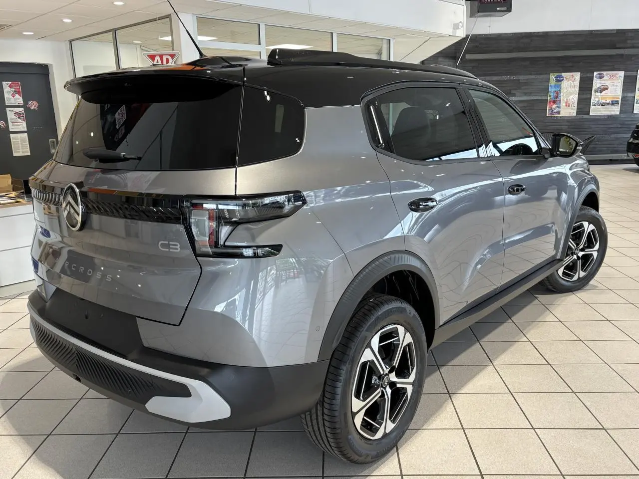Vue 3/4 arrière droite du Citroën C3 Aircross 2026 gris métallisé avec toit noir et jantes alliage 17 pouces.