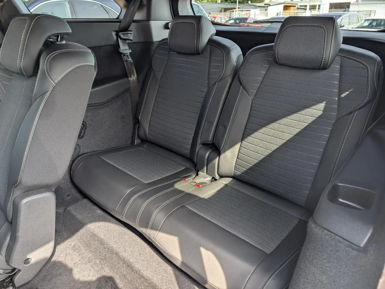 Vue rapprochée de la banquette arrière 2 places en tissu noir avec surpiqûres claires du Peugeot 5008 blanc.