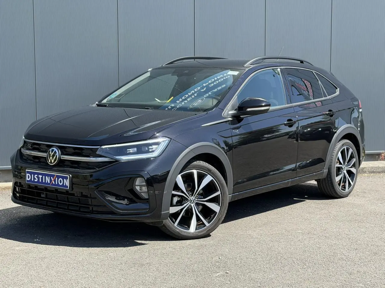 Volkswagen Taigo noir en 3/4 avant droit, avec jantes alliage 18 pouces et calandre R-Line visible.