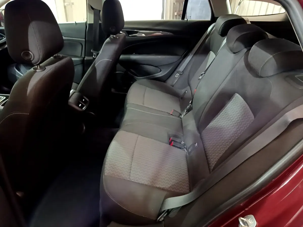 Vue intérieure côté droit des sièges arrière en tissu gris d’une Opel Insignia rouge, avec ceinture de sécurité visible.