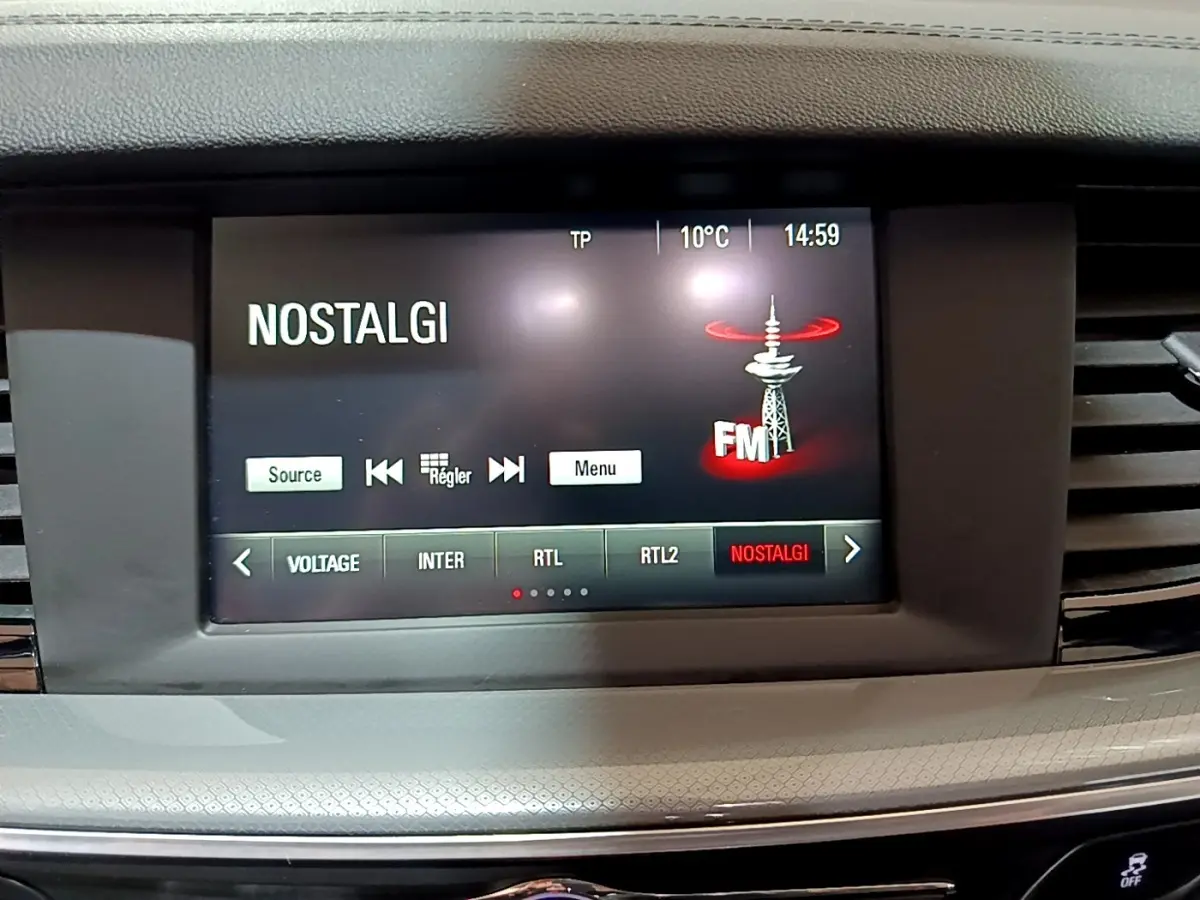 Écran tactile central de l’Opel Insignia 2019 affichant la radio FM sur fond noir, entouré de la console grise.