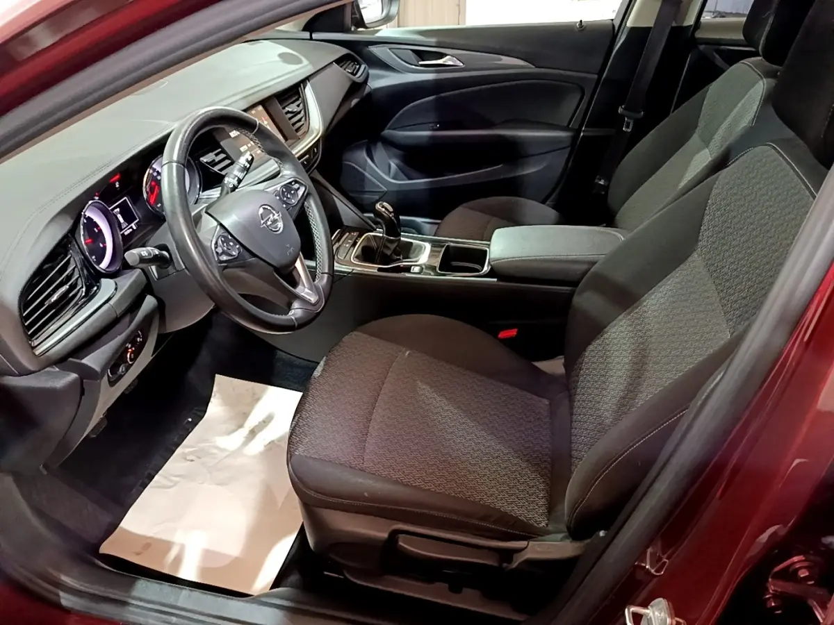 Intérieur avant droit de l’Opel Insignia rouge 2019, volant cuir multifonctions et console centrale avec boîte manuelle.