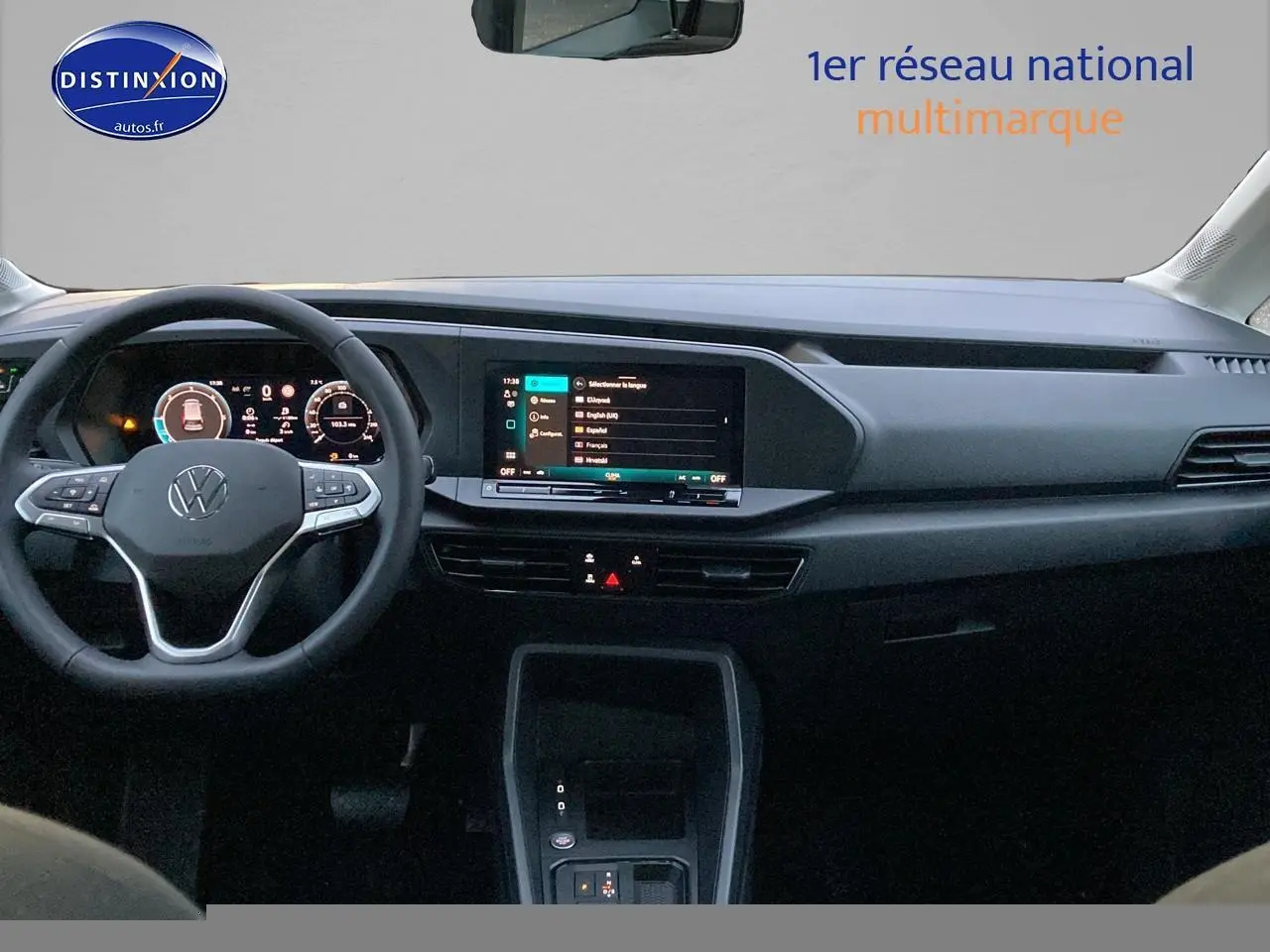 Vue intérieure frontale du tableau de bord noir du Volkswagen Caddy 2025 avec écran tactile et volant multifonction.