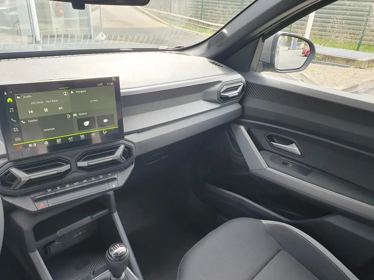 Intérieur côté passager du Dacia Dokker Van gris schiste, avec tableau de bord moderne et écran tactile central.