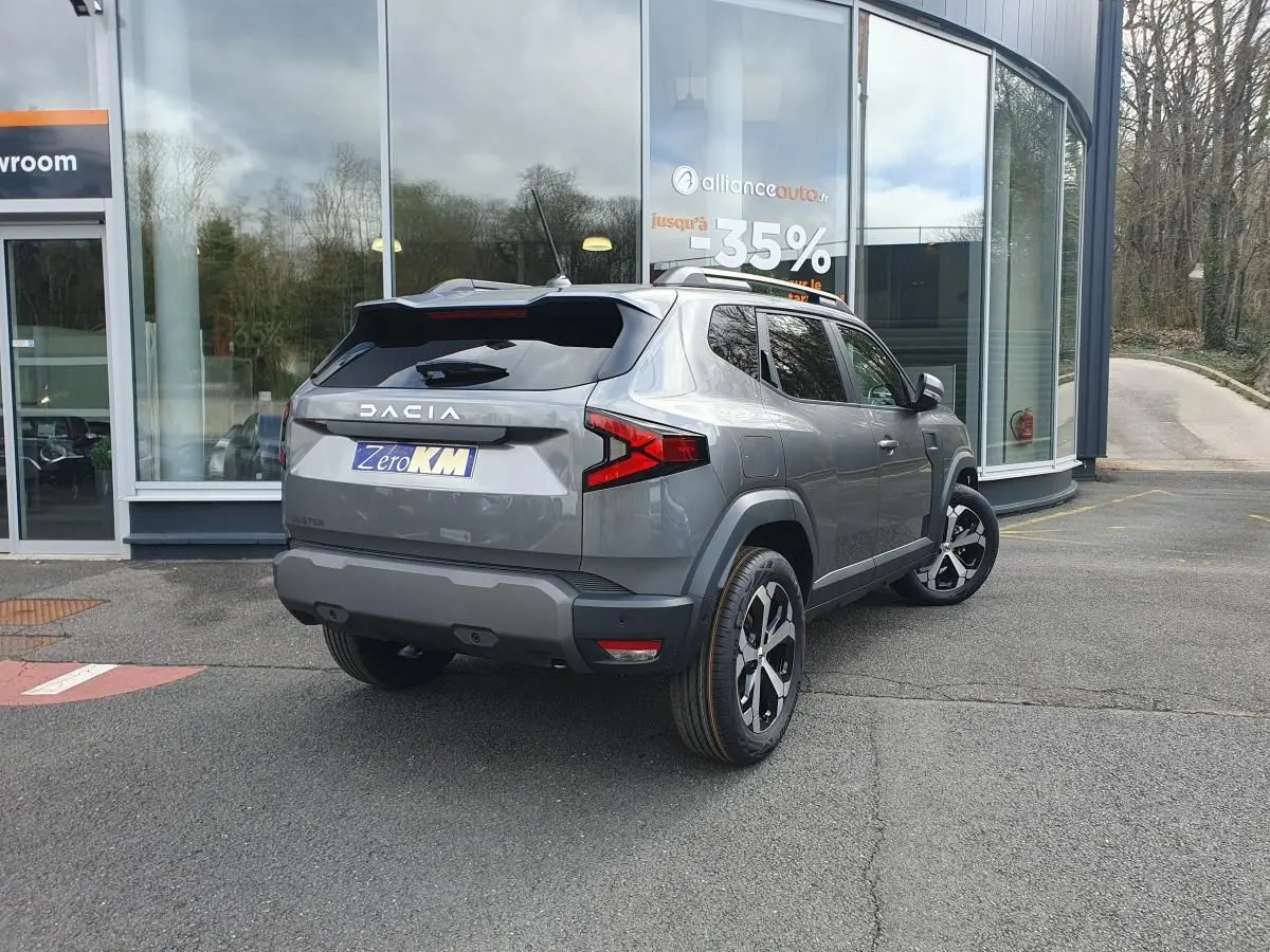 Vue 3/4 arrière droit d'un Dacia Dokker Van gris schiste métallisé avec jantes alliage et barres de toit fixes.