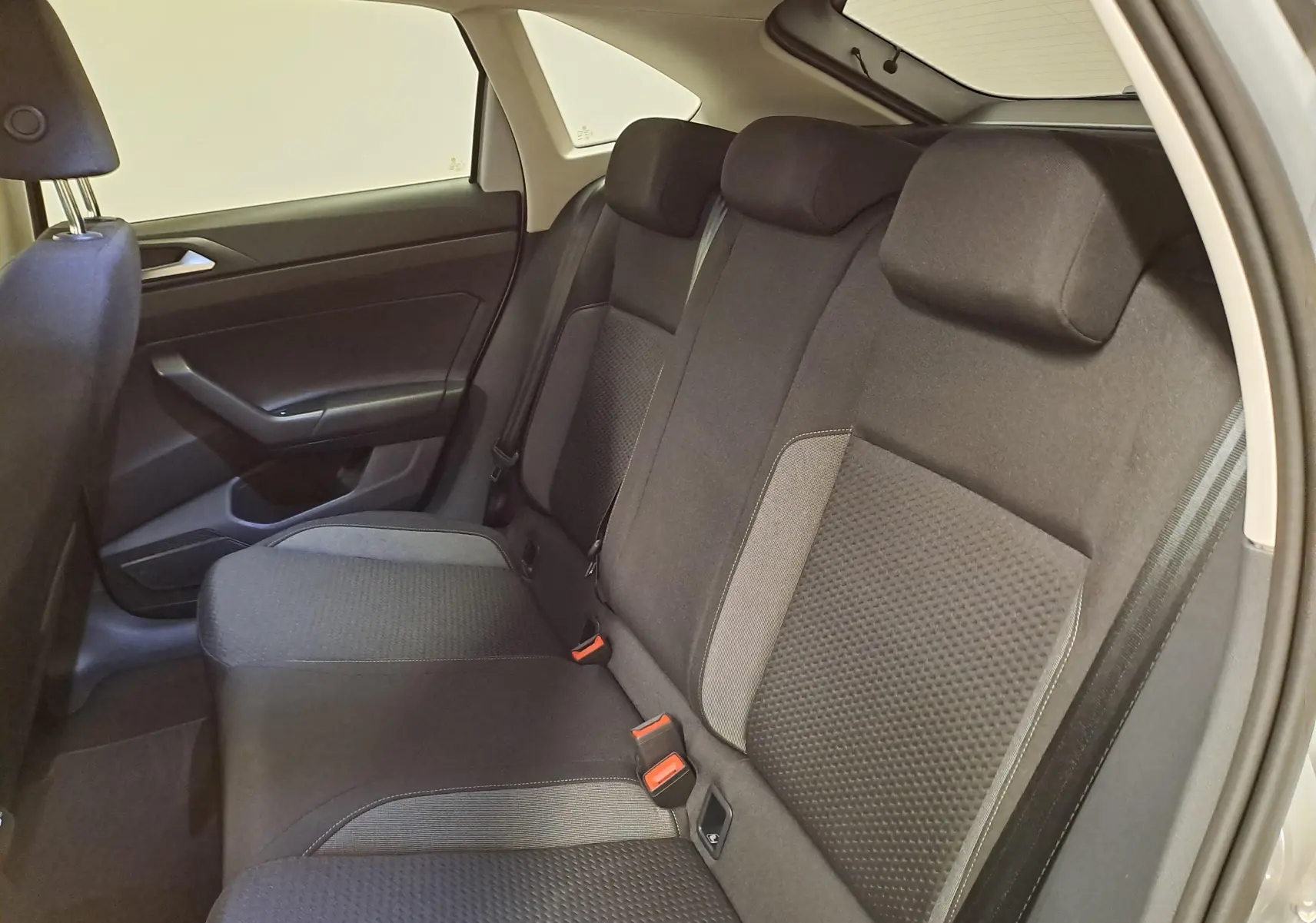Vue intérieure côté gauche des sièges arrière noirs du Volkswagen Taigo 2025, avec ceinture et appuie-têtes visibles.