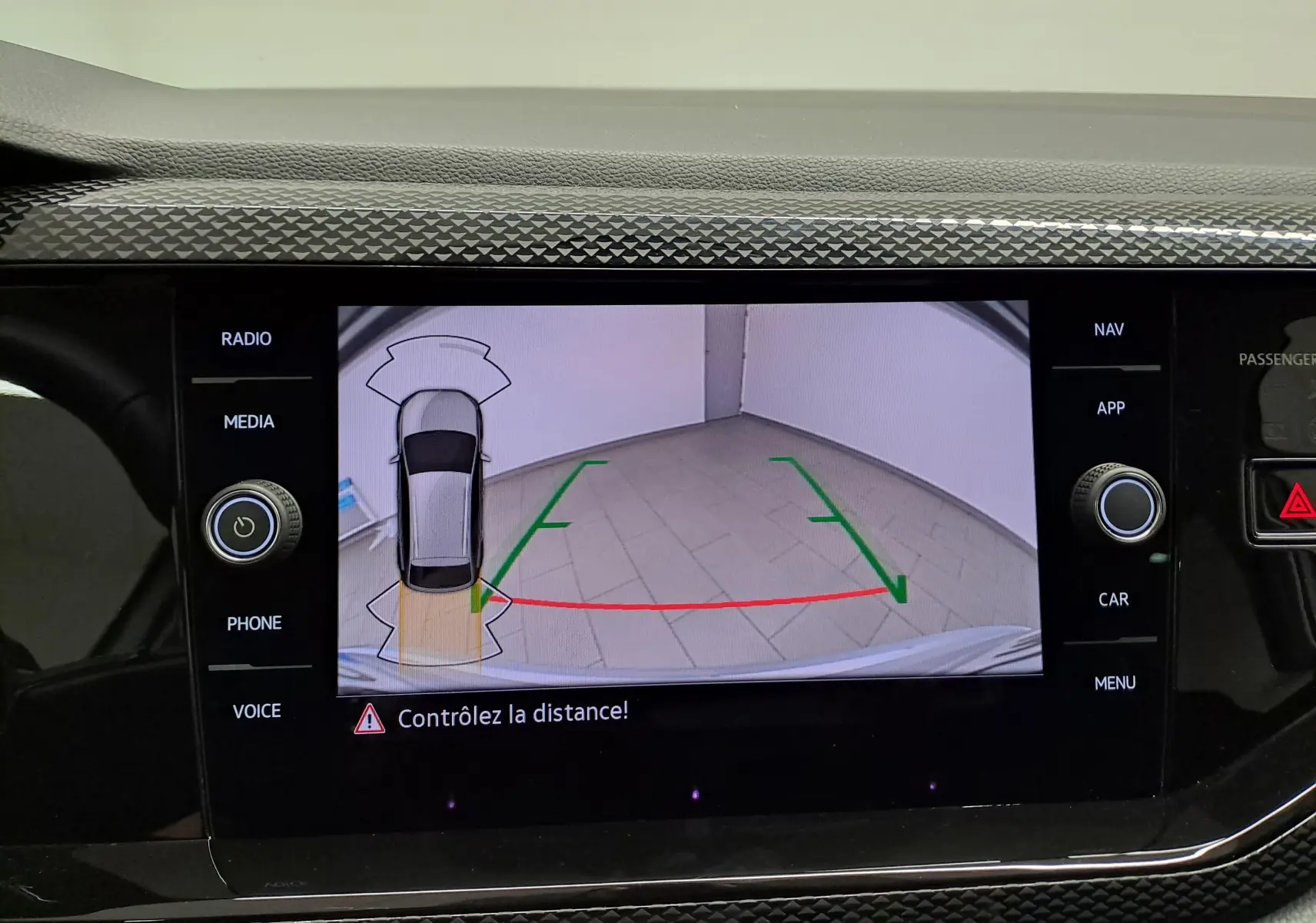 Écran de caméra de recul du Volkswagen Taigo 2025 en reflet d'argent, avec guidage de trajectoire et alertes de distance.