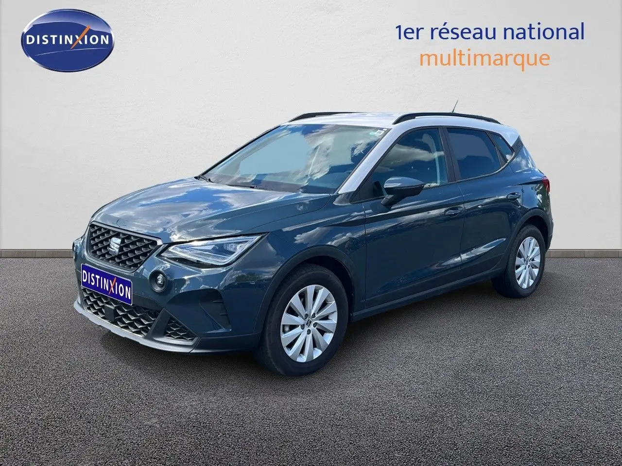 SEAT Arona bleu Fjord avec toit blanc, vue 3/4 avant droit, mettant en valeur ses lignes dynamiques et jantes argentées.