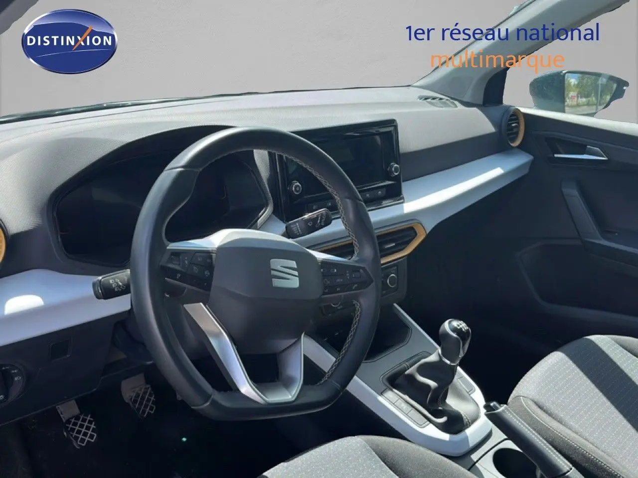 Intérieur de la SEAT Arona 2025 vu côté conducteur, volant multifonction et levier de vitesse manuel en vue rapprochée.