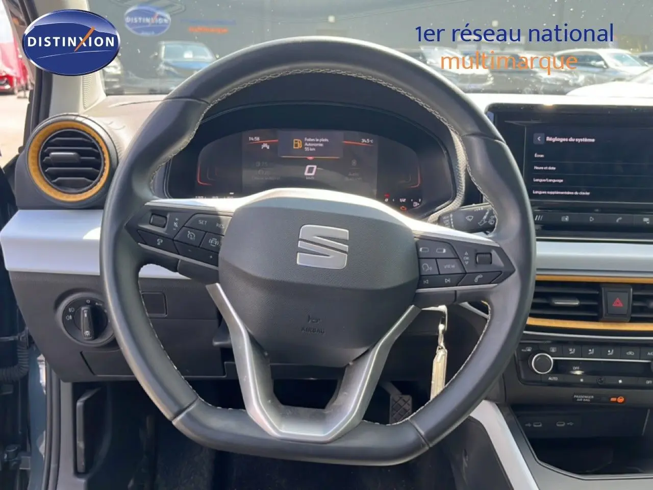 Vue centrée sur le volant noir de la SEAT Arona 2025, avec tableau de bord digital et détails intérieurs jaunes.