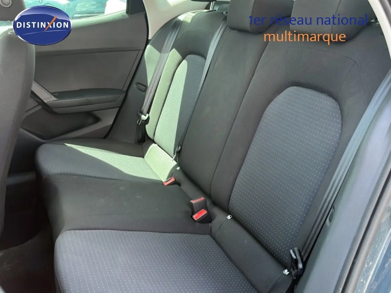 Vue latérale intérieure montrant la banquette arrière en tissu gris et noir du SEAT Arona 2025.