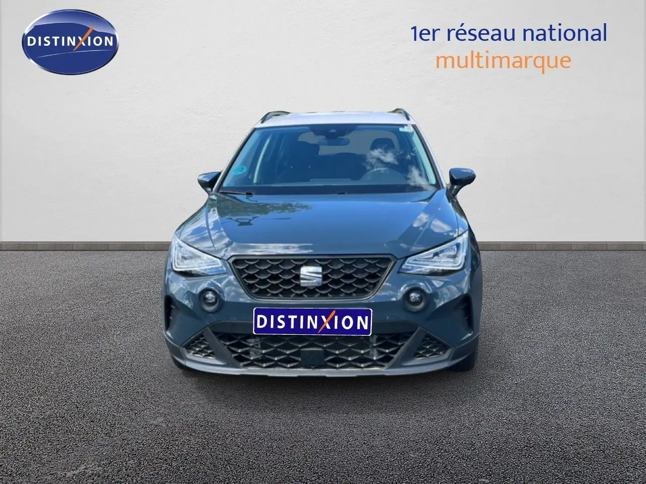 Vue avant d'un SEAT Arona bleu Fjord avec toit blanc, calandre noire et phares LED allumés.