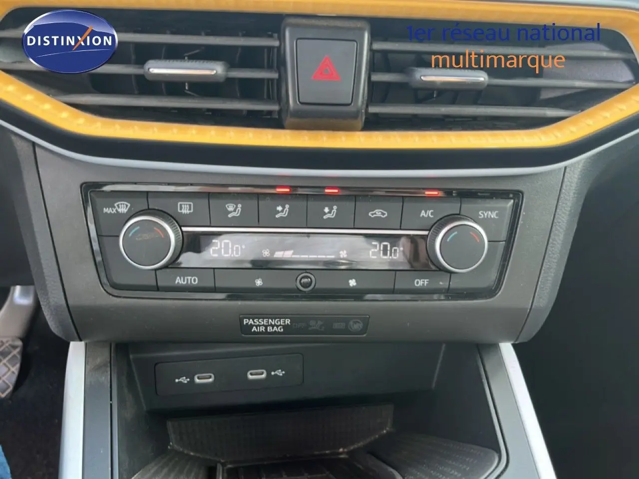 Vue rapprochée de la console centrale du SEAT Arona 2025, avec climatisation digitale et finitions jaunes contrastantes.