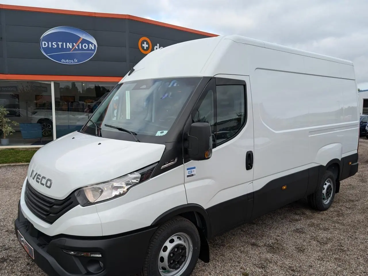 Fourgon Iveco Daily blanc en vue 3/4 avant droit, avec calandre noire et rétroviseurs noirs contrastants.