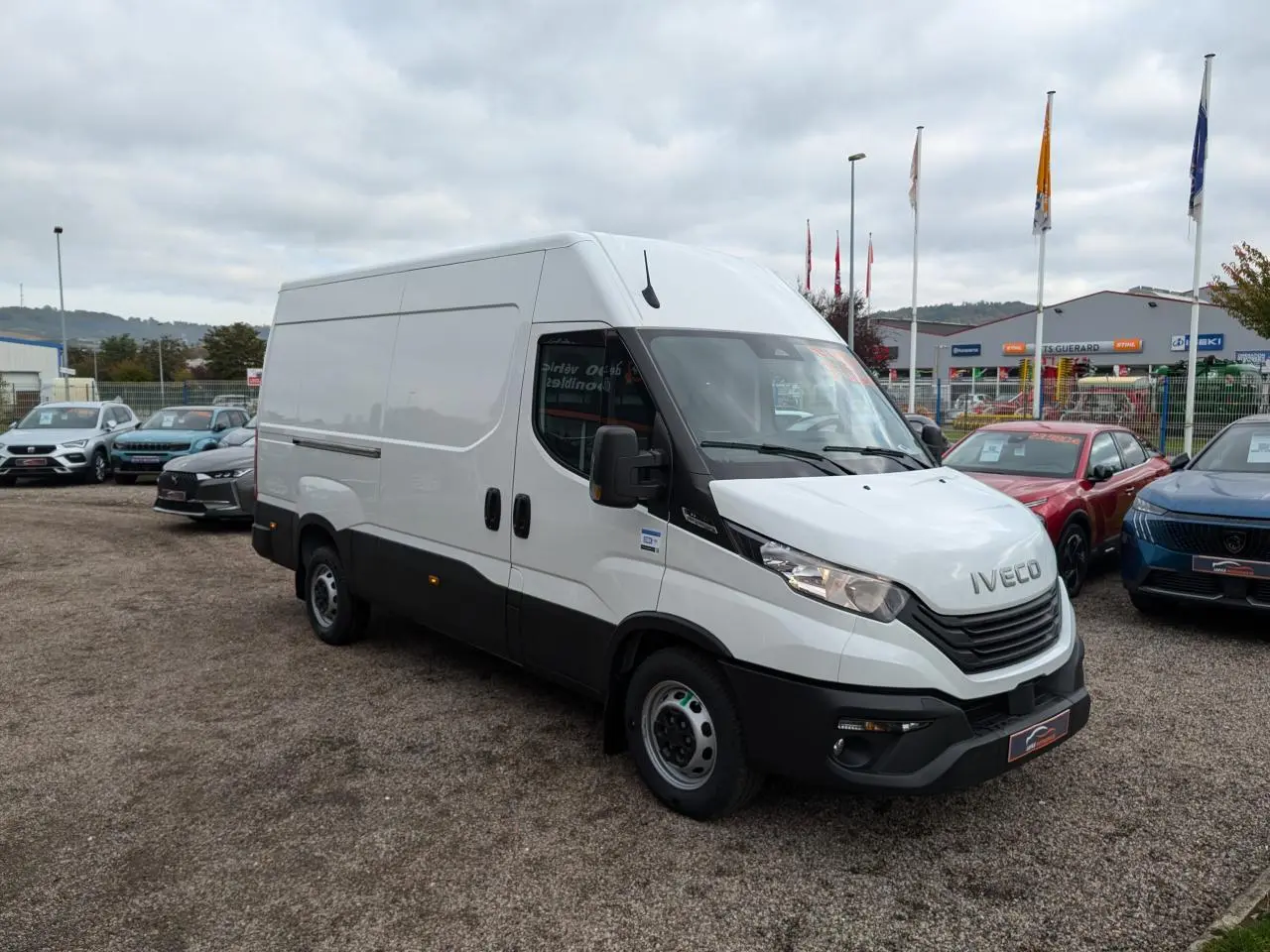 Fourgon Iveco Daily blanc en vue 3/4 avant droit avec calandre noire et portes latérales coulissantes.