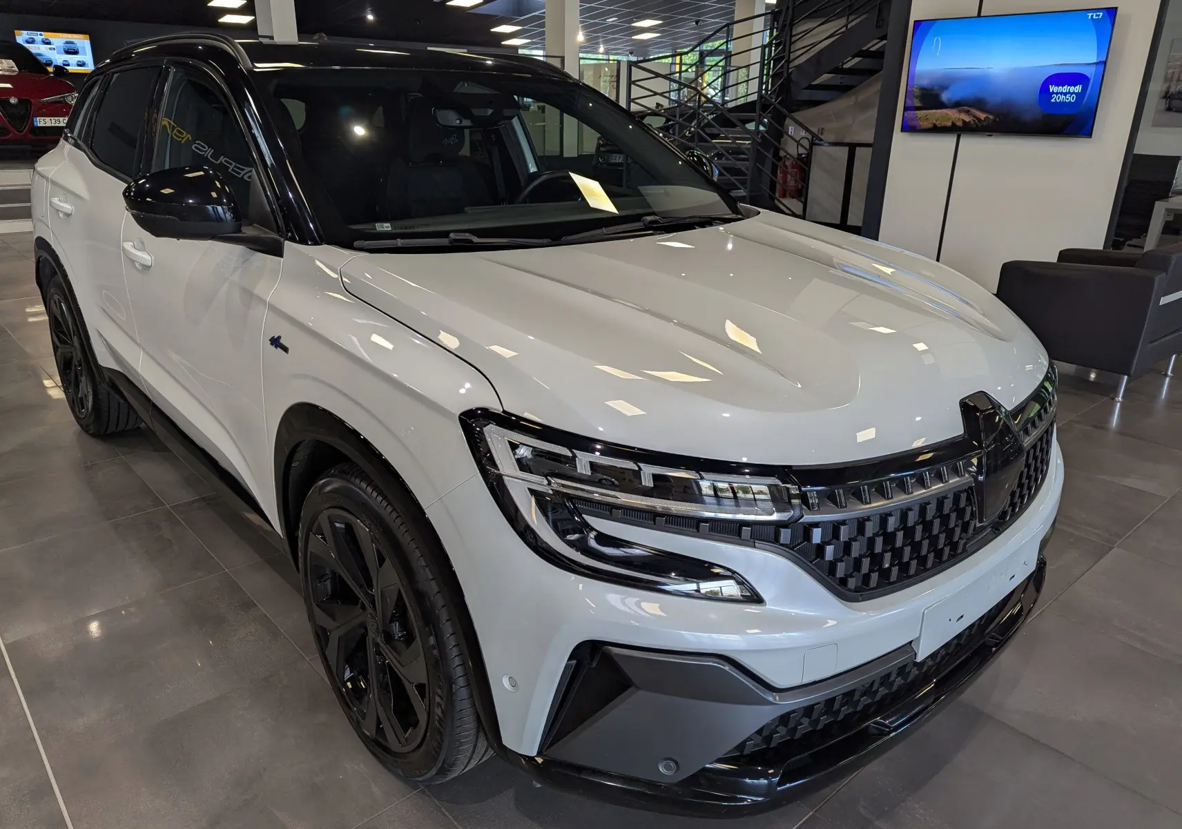 Renault Austral E-Tech blanc nacré avec toit noir, vue 3/4 avant droit, calandre et jantes noires distinctives.