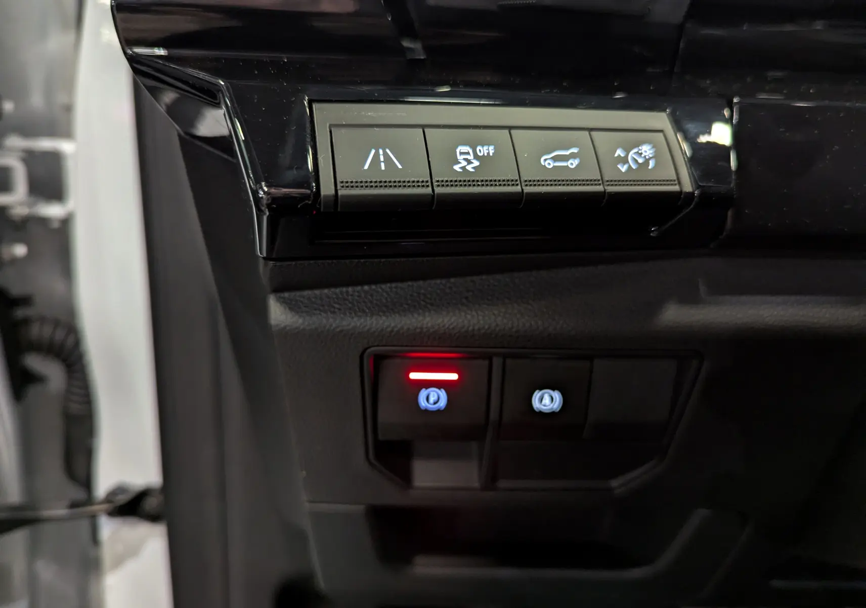 Gros plan sur les commandes de sécurité et assistance du tableau de bord du Renault Austral blanc nacré 2023.