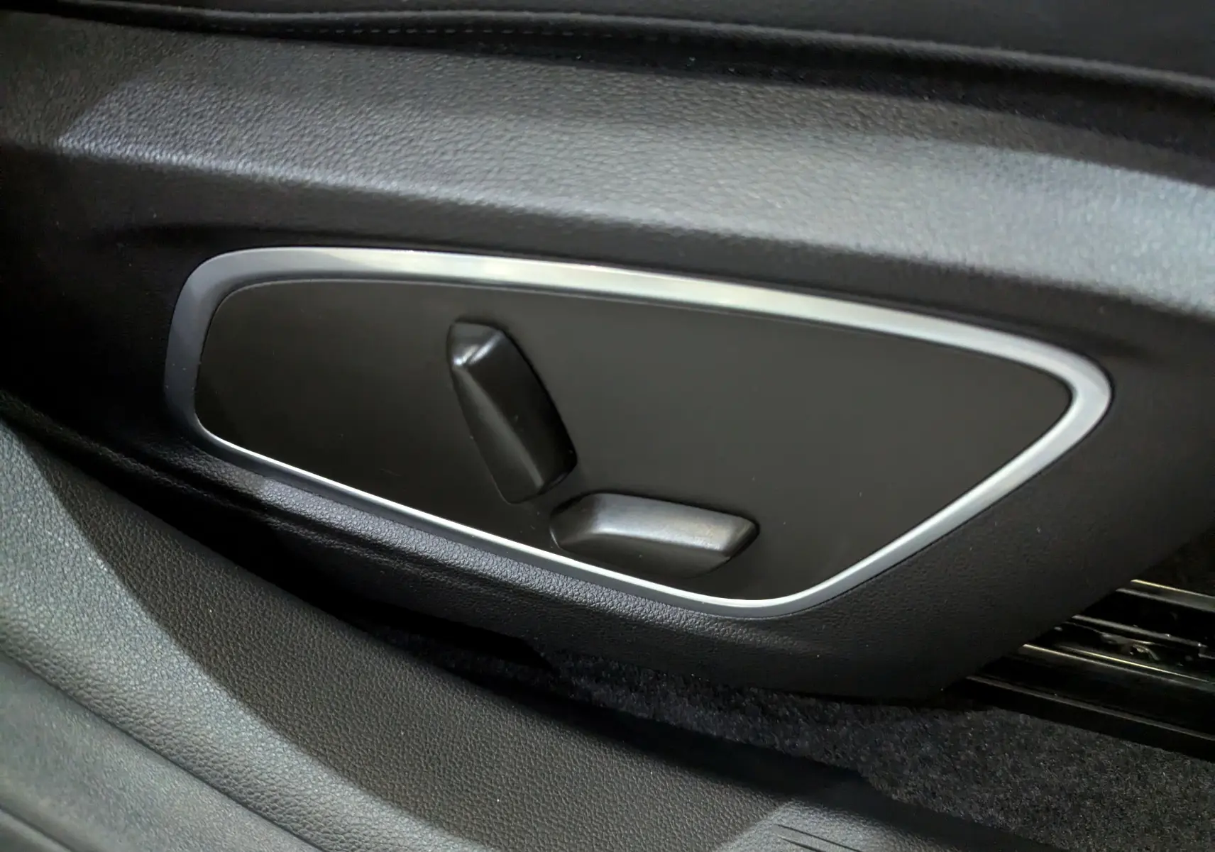 Gros plan sur les commandes électriques de réglage du siège côté conducteur dans l'habitacle du Renault Austral 2023.