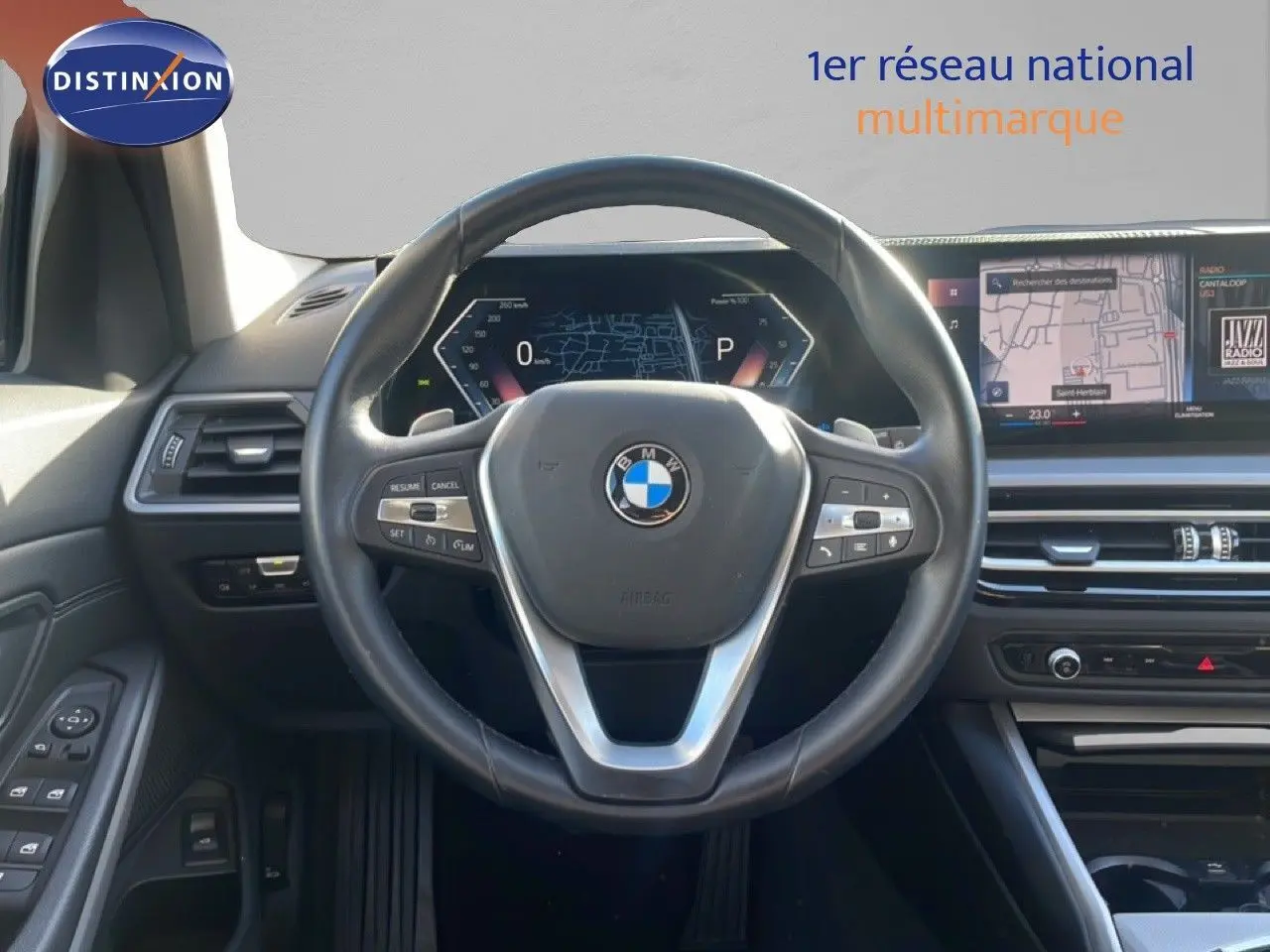 Vue intérieure centrée sur le volant cuir noir et le tableau de bord digital d'une BMW Série 3 Touring F31 316d.