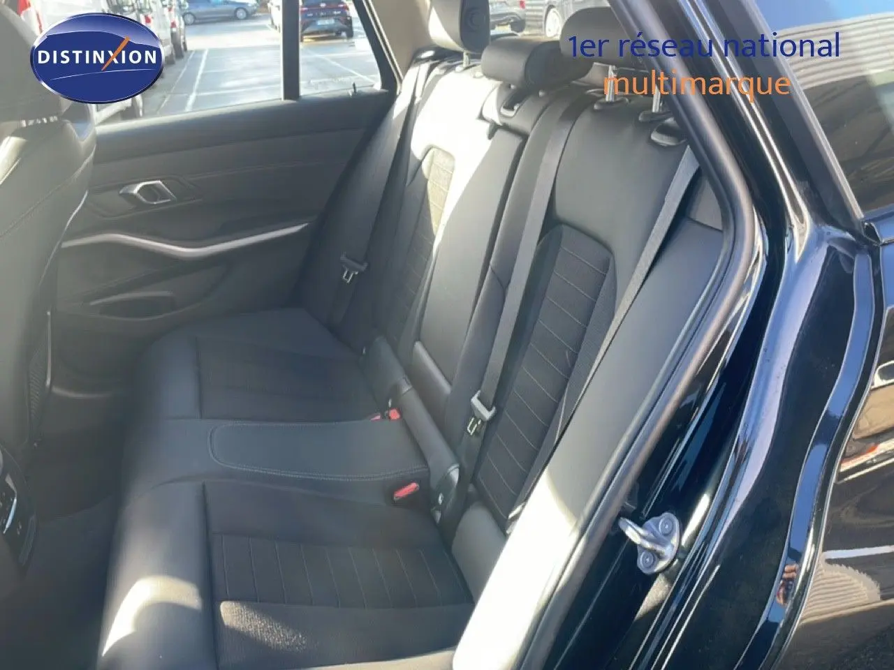 Vue intérieure côté droit sur les sièges arrière en cuir noir d'une BMW Série 3 Touring F31 noire, avec ceinture de sécurité visible.
