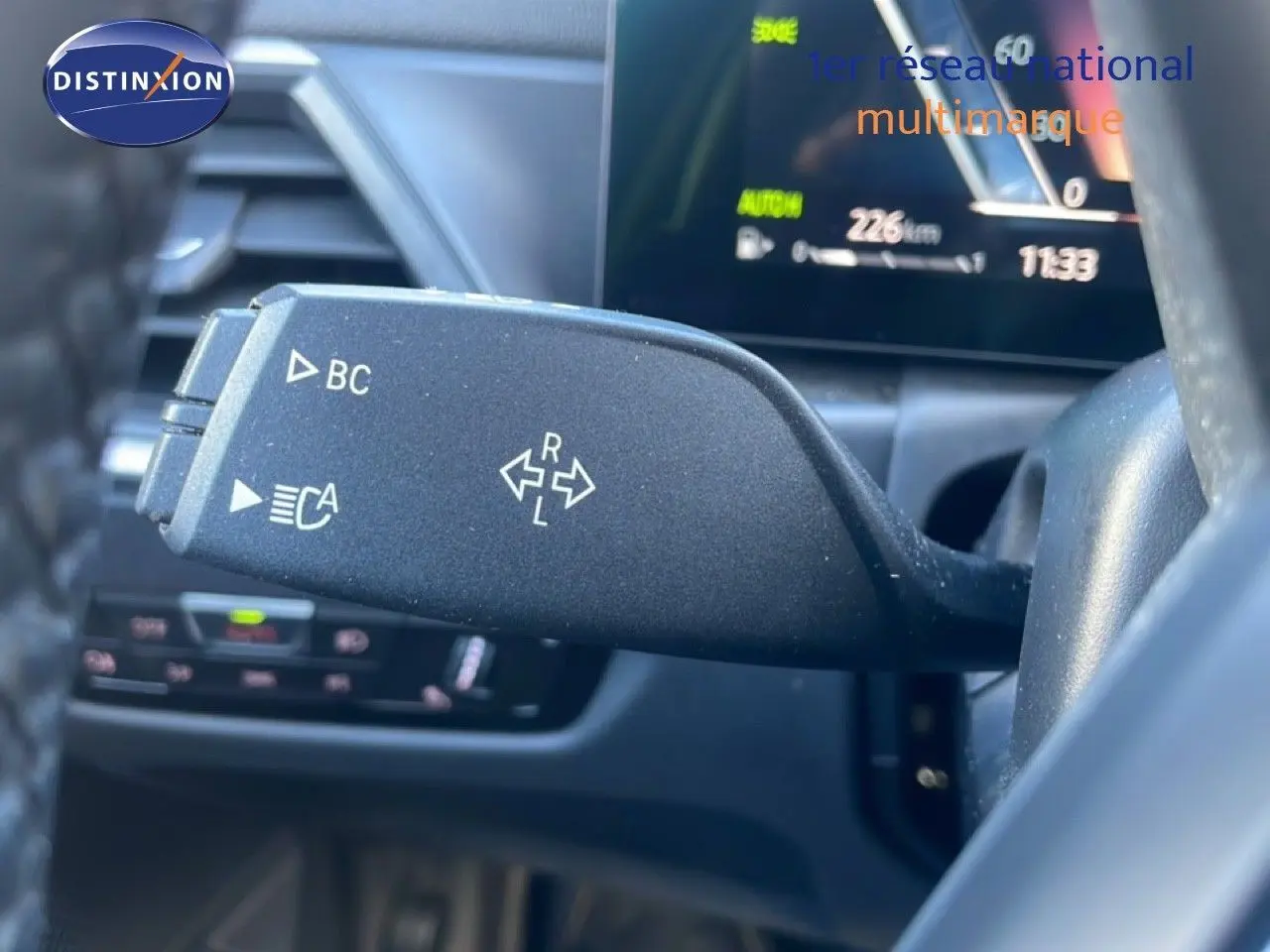Gros plan sur la commande de clignotant noire à gauche du volant dans l’habitacle d’une BMW Série 3 Touring F31 noire.