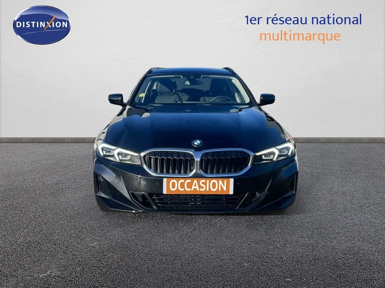 BMW Série 3 Touring F31 noir Saphir vue de face, mettant en valeur la calandre double haricot et les phares LED allumés.
