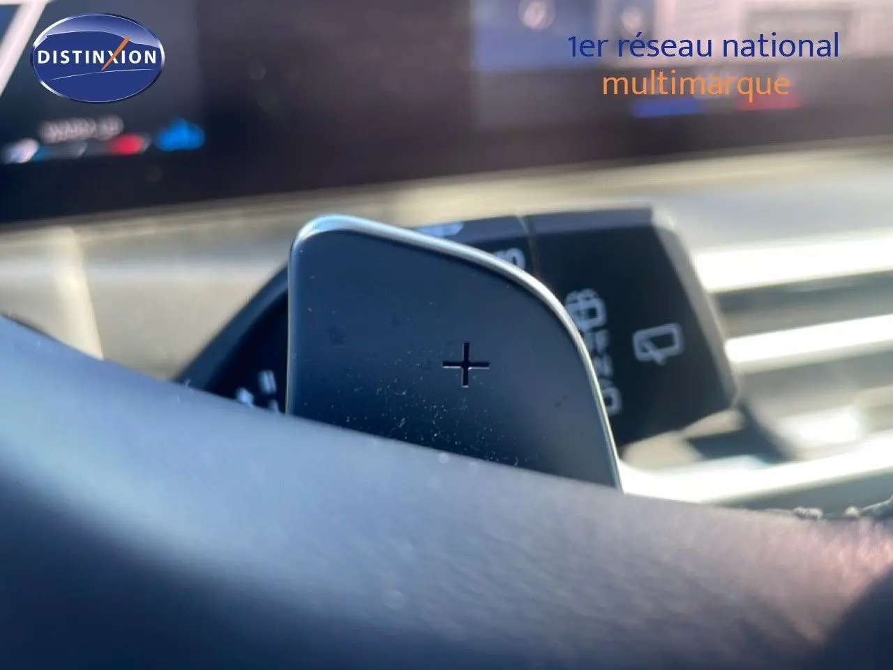Gros plan sur la palette de changement de vitesse + au volant d’une BMW Série 3 Touring 316D noir sapphire, intérieur moderne.