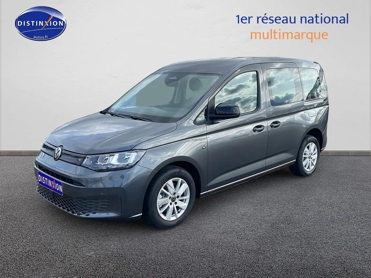 Volkswagen Caddy gris indien en vue 3/4 avant droit, avec vitres teintées et jantes alliage.