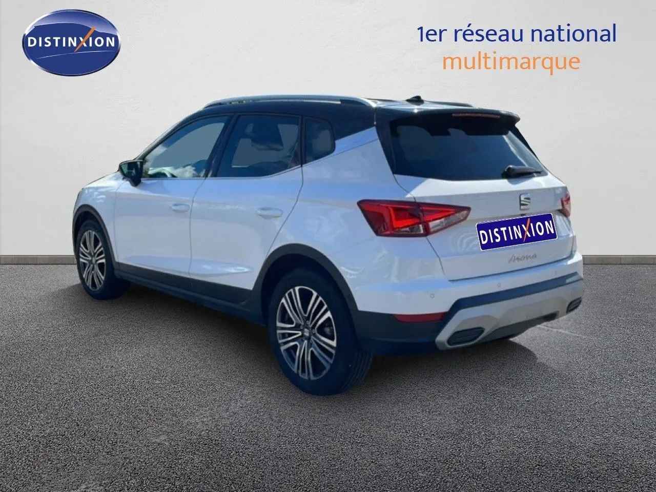 Vue 3/4 arrière droite d’un SEAT Arona blanc Nevada avec toit noir, jantes alliage et feux arrière LED.