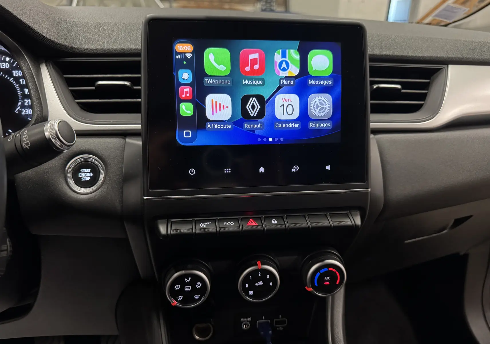 Vue rapprochée du tableau de bord noir du Renault Captur 2021, avec écran tactile central affichant des applications connectées.