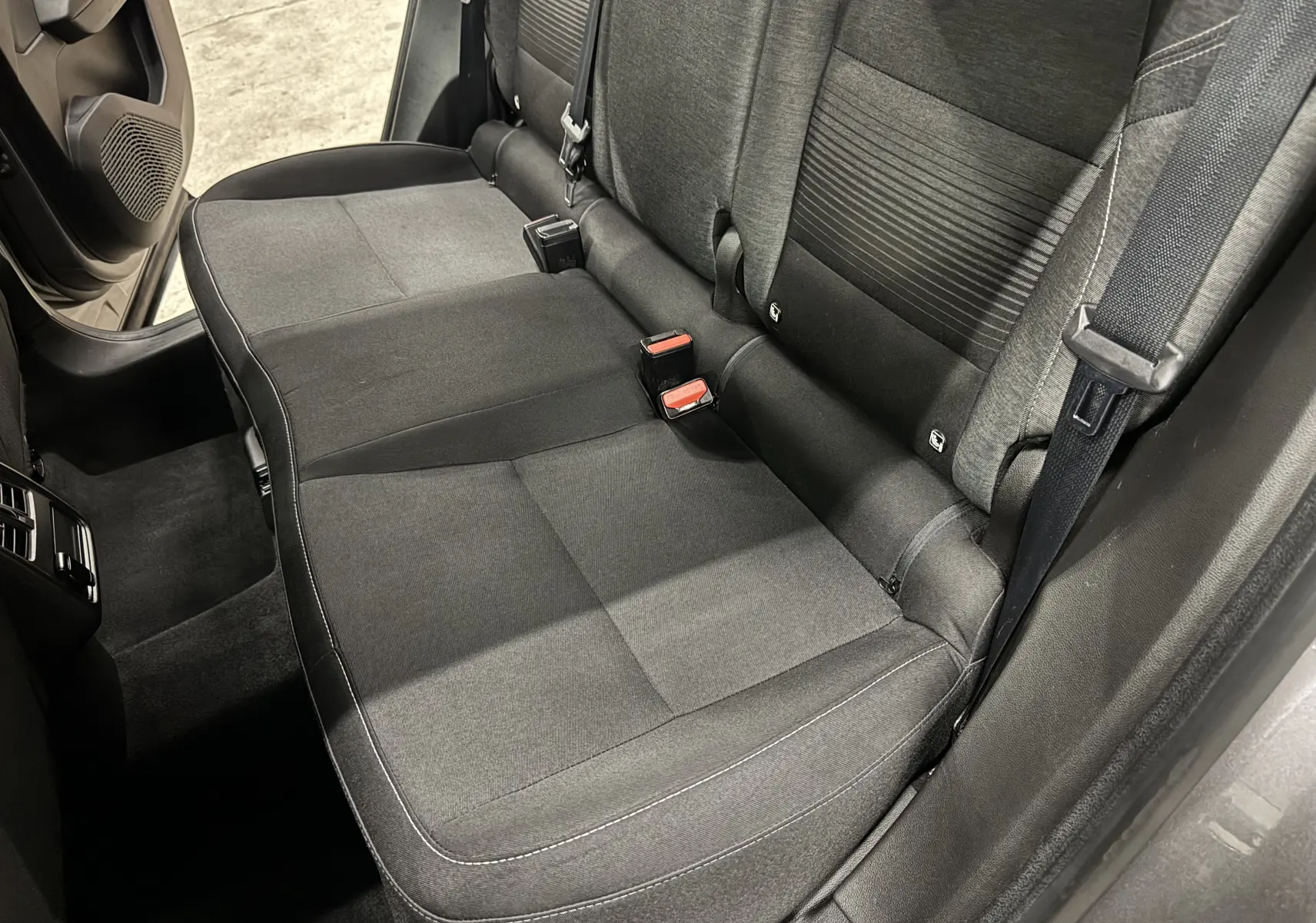 Vue intérieure côté arrière droit du siège arrière gris foncé du Renault Captur TCE 90 CH Business 2021 avec ceintures de sécurité visibles.