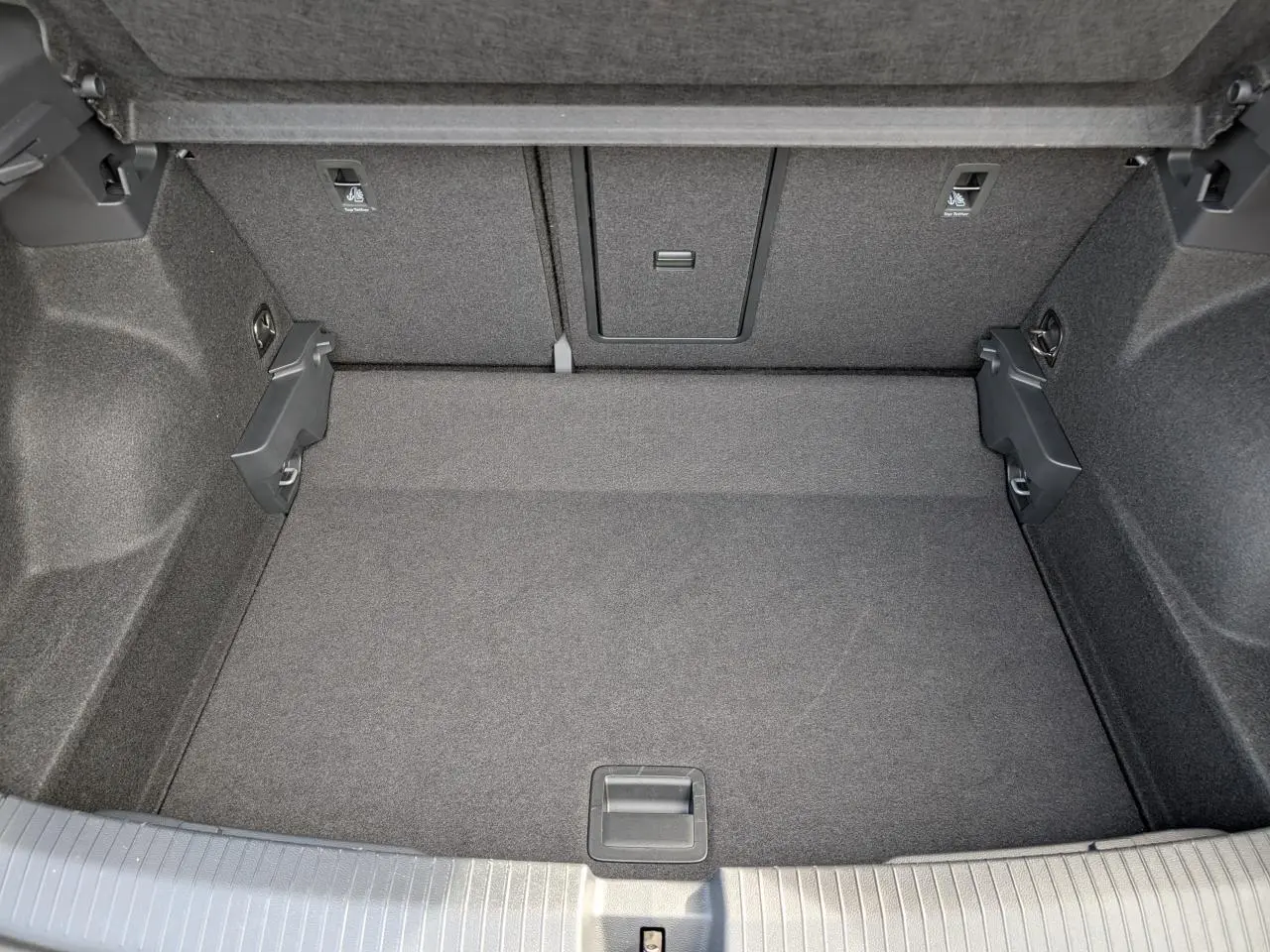 Coffre spacieux vu de dessus du Volkswagen T-Roc gris 2025 avec revêtement intérieur gris foncé.