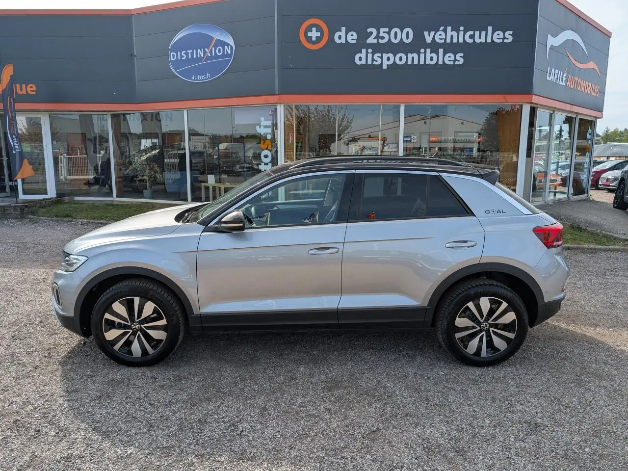 Volkswagen T-Roc gris vue de profil côté gauche avec jantes alliage et toit noir, version GOAL 2025.