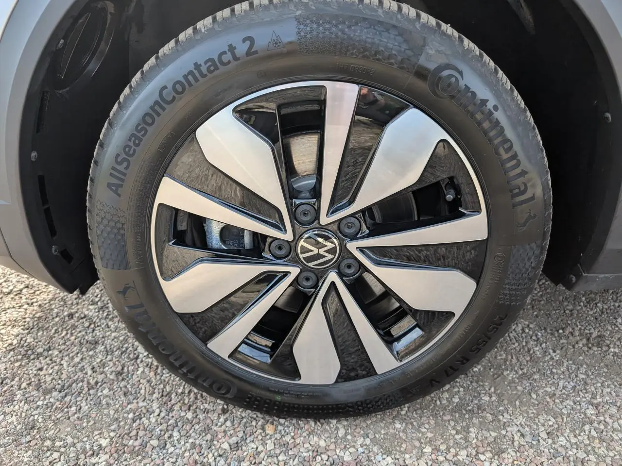 Gros plan sur la jante alliage léger 17 pouces Johannesburg noire et argentée du Volkswagen T-Roc gris.