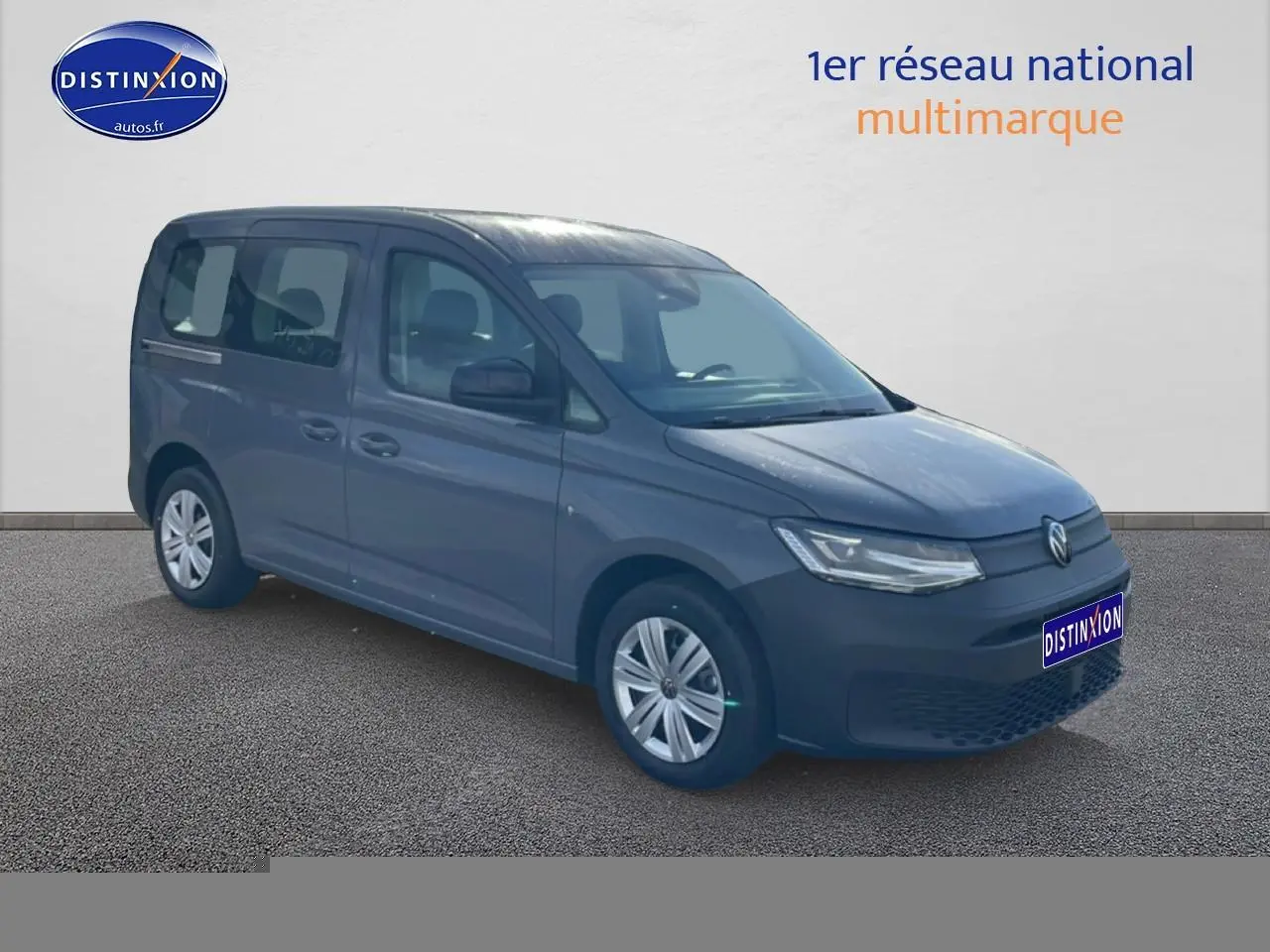 Volkswagen Caddy gris pur vue 3/4 avant droit sur fond neutre avec logo Distinxion visible.