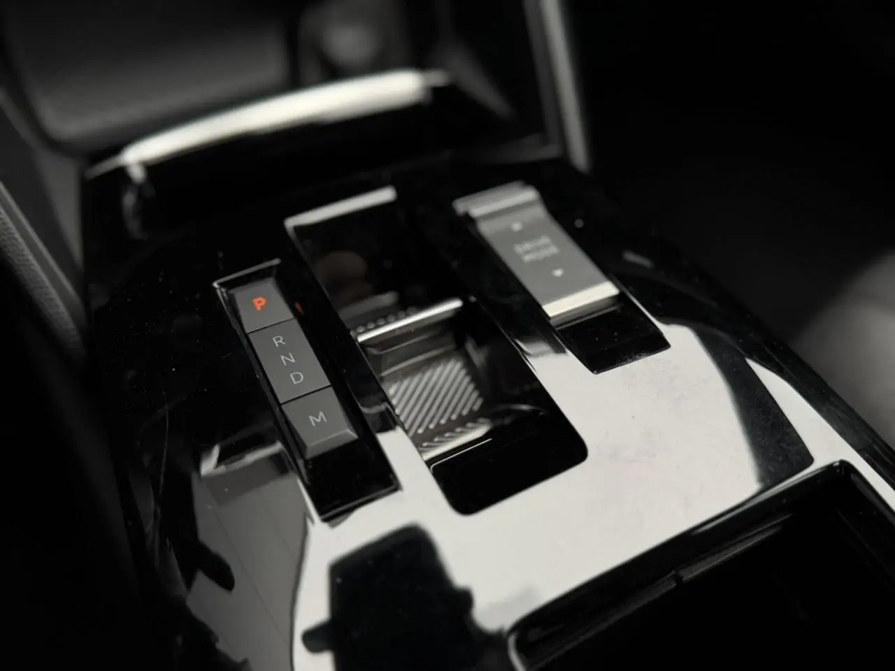 Gros plan sur la console centrale noire brillante de la Citroën C4 2024, avec sélecteur de boîte automatique et bouton start/stop.