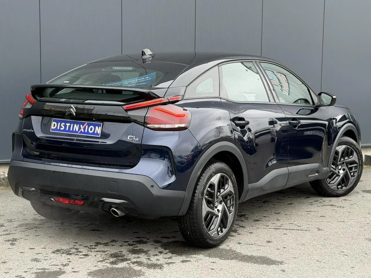 Vue 3/4 arrière droite de la Citroën C4 2024 bleu Eclipse avec toit noir Perla et jantes alliage 18 pouces.