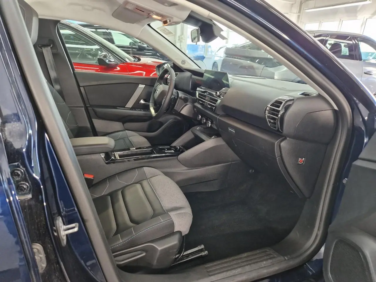 Vue 3/4 avant droite d'une Citroën C4 2024 bleu Eclipse avec toit noir et jantes alliage 18 pouces.